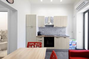 墨西拿的住宿－Aparthotel Ganzirri Messina，厨房配有白色橱柜和木桌