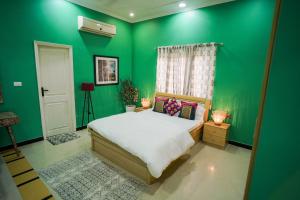 Woodlands Cottage - Luxury stay في جودبور: غرفة نوم خضراء بسرير وجدران خضراء +24 صورة