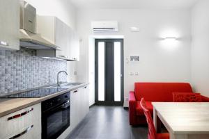 墨西拿的住宿－Aparthotel Ganzirri Messina，一间厨房,内设桌子和红色沙发