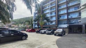 a parking lot with cars parked in front of a building at Chic condominium karon in Karon Beach