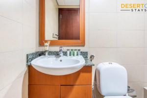 un bagno con lavandino, water e specchio di Fully Furnished 1 Bed in JLT, Hosted by Desert City Stays a Dubai