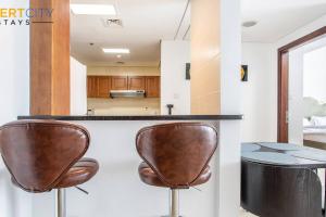 una cucina con due sedie marroni a un bancone di Fully Furnished 1 Bed in JLT, Hosted by Desert City Stays a Dubai Altre 10 foto