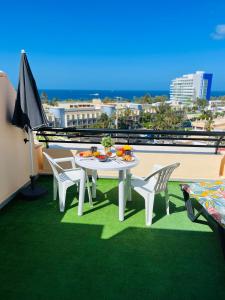 un tavolo e sedie su un balcone con vista sull'oceano di Apartamento Las vistas a Morro del Jable