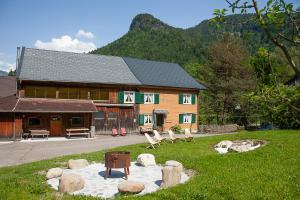ein Haus mit einem Garten mit Stühlen davor in der Unterkunft Alps Hoamat in Mellau