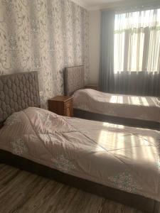 a bedroom with two beds and a window at Ksenya B&B in Tatʼev