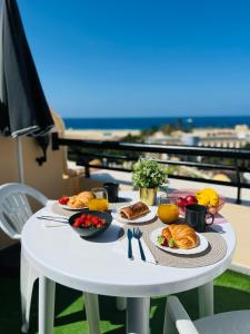 un tavolo bianco con cibo sopra con vista sulla spiaggia di Apartamento Las vistas a Morro del Jable