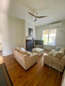 a living room with two couches and a ceiling fan at Somerby! in Albury