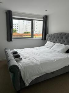 a bed in a bedroom with a large window at Stunning Waterfront Western harbour Apartment in Edinburgh