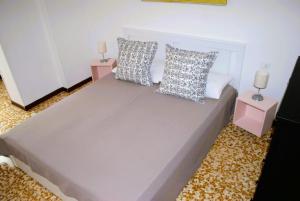een slaapkamer met een groot bed met 2 nachtkastjes bij Appartamento Intero Bilocale in Centro Storico a Voghera-Oltrepò Pavese in Voghera