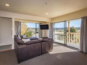 a living room with a couch and a balcony at Three Peak Lodge - National Park Holiday Home in National Park