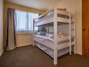 a bedroom with two bunk beds and a window at Three Peak Lodge - National Park Holiday Home in National Park