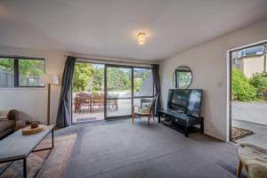 a living room with a couch and a tv at Links Lifestyle - Duvauchelle Holiday Home in Duvauchelle