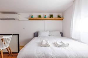 um quarto com uma cama branca com duas toalhas em Triplex on the beach - Hayarkon 30 em Tel Aviv