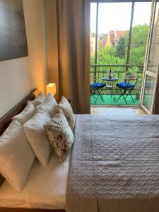 a bedroom with a bed with pillows and a balcony at Royal Apartment Krakow in Krakow