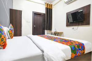 a bedroom with two beds and a flat screen tv at FabExpress SP7 in Indore