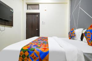 a bedroom with a bed with a colorful comforter at FabExpress SP7 in Indore