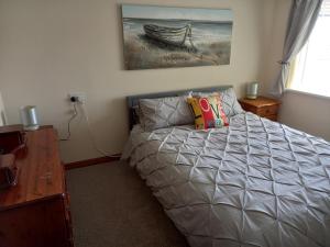 a bedroom with a bed and a desk and a painting at Pet Friendly Beautiful Detached Cottage close to Spurn Point, Easington and Withersea in Hull