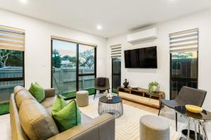 a living room with a couch and a tv at Pristine Modern Central Home - Netflix - Heatpump in Auckland
