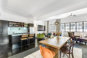 sala de estar con mesa y cocina en Gorgeous NY Style Loft in CBD - Netflix Wifi, en Auckland