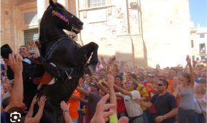 una multitud de personas con un caballo saltando en el aire en Your House in Menorca, en Ciutadella