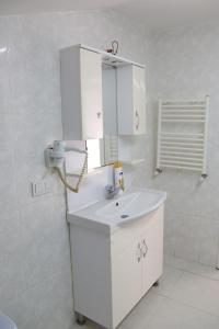 a bathroom with a white sink and a mirror at Memory Suites in Buyukcekmece