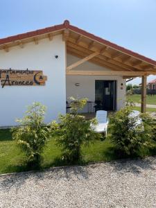 a white house with a bench and a sign on it at Apartamentos Aronces in Cudillero