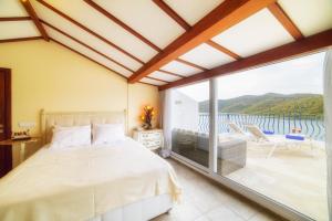 a bedroom with a bed and a large window at Yalicapkini Boutique Hotel in Gulluk