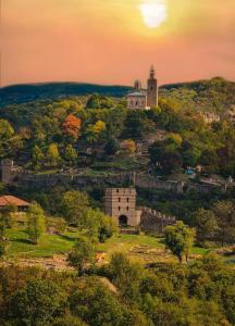 um velho castelo numa colina com o pôr-do-sol ao fundo em Ross em Veliko Tarnovo