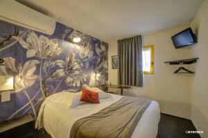 een hotelkamer met een bed met bloemenbehang bij Hôtel The Originals Access, Bourges Nord Saint-Doulchard in Bourges