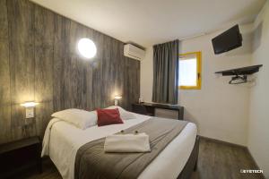 een hotelkamer met een bed met een handtas erop bij Hôtel The Originals Access, Bourges Nord Saint-Doulchard in Bourges