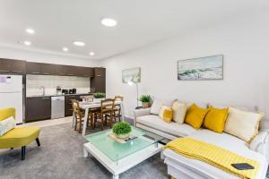 una sala de estar con un sofá y una mesa en Hideaway Apartment with pool and free parking, en Auckland