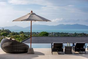 un patio con mesa, sombrilla y sillas en Villa Mandra - Beautiful 4 Bedroom Luxury Pool Villa KBR2 en Koh Samui