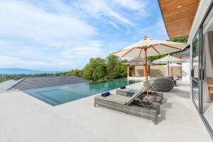 un patio al aire libre con sombrilla y sillas y una piscina en Villa Mandra - Beautiful 4 Bedroom Luxury Pool Villa KBR2 en Koh Samui
