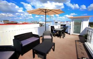 a patio with tables and chairs and an umbrella at Isa SkyHouse Algarve in Portimão