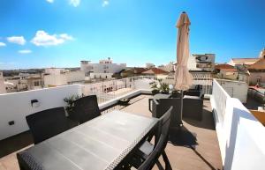 波爾蒂芒的住宿－Isa SkyHouse Algarve，阳台配有桌子和雨伞。
