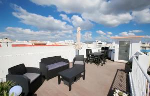 a balcony with chairs and a table on a roof at Isa SkyHouse Algarve in Portimão