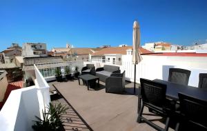 a balcony with chairs and an umbrella on a building at Isa SkyHouse Algarve in Portimão