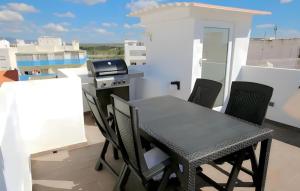 a table and chairs on a balcony with a grill at Isa SkyHouse Algarve in Portimão +32 photos