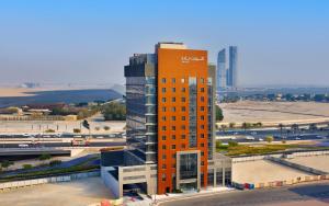 a tall orange building in front of a parking lot at Courtyard by Marriott Culture Village, Dubai in Dubai