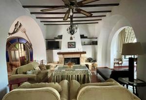 uma sala de estar com uma ventoinha de tecto e uma lareira em Cortijo Doñana em La Puebla de Cazalla