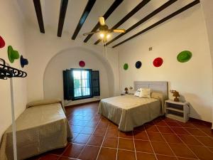 1 dormitorio con 1 cama y ventilador de techo en Cortijo Doñana, en La Puebla de Cazalla