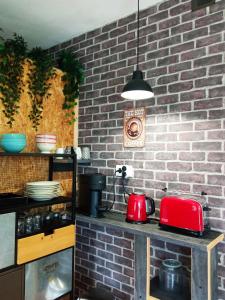 a kitchen with a red appliance on a brick wall at Las Palmeras in Alberique