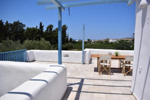 a patio with a table and chairs on a roof at Lovely View in Kampos Paros