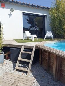 a wooden deck with a ladder next to a swimming pool at Superbe Villa in Villeneuve