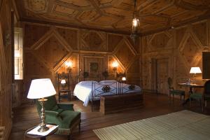 Un dormitorio con una cama y una lámpara. en Palazzo Juvalta, en Teglio