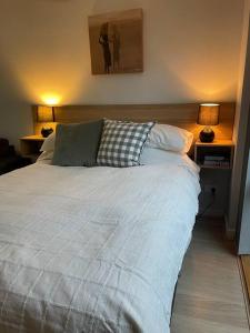 a bedroom with a white bed with two lamps at oasis by the beach in Glenelg