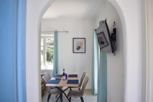 a dining room with a table and chairs and a tv at Lovely View in Kampos Paros