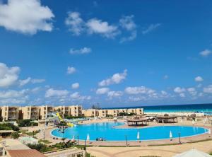 a view of a resort with a swimming pool and the beach at شاليه زمردة in Dawwār Shindī Fannūsh