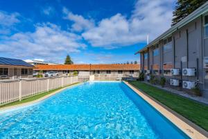 a swimming pool in front of a building at Hospitality Esperance SureStay Collection by Best Western in Esperance