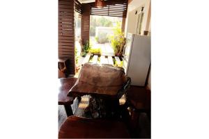 a table and chairs in a room with a refrigerator at Pornkasem House in Chiang Rai